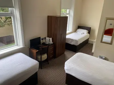 a hotel room with two beds and a desk with a computer at The New Brighton Hotel in New Brighton