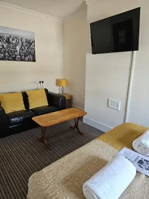 a living room with a couch and a table at The New Brighton Hotel in New Brighton