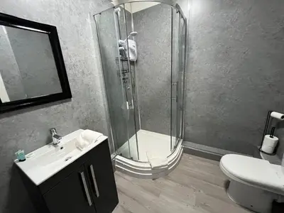 a bathroom with a shower and a sink and a toilet at The New Brighton Hotel in New Brighton