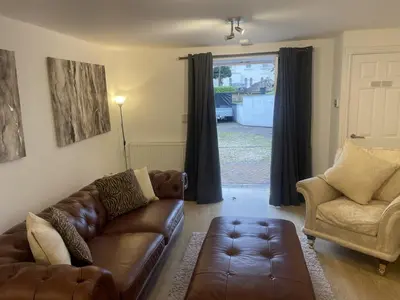 a living room with a couch and a chair and a window at Beach House Courtyard 2 bed in Southport