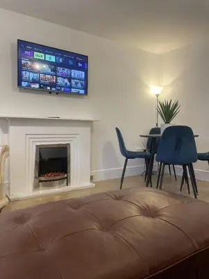 a living room with a fireplace and a tv on the wall at Beach House Courtyard 2 bed in Southport
