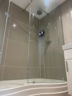 a shower with a glass door in a bathroom at Beach House Courtyard 2 bed in Southport