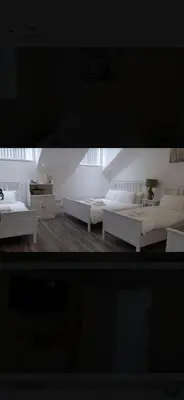 a white room with two beds and a table at Beautiful six bedroom townhouse citybreak close to city centre in Liverpool