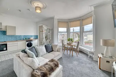 a living room with a couch and a table at Fairhaven View by Guestz in Lytham St Annes