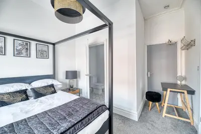 a bedroom with a bed and a desk with a lamp at Fairhaven View by Guestz in Lytham St Annes