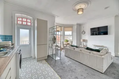 a living room with a couch and a table at Fairhaven View by Guestz in Lytham St Annes