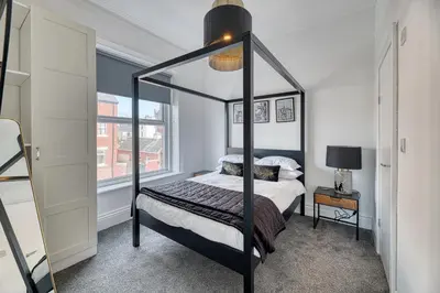 a bedroom with a canopy bed and a window at Fairhaven View by Guestz in Lytham St Annes