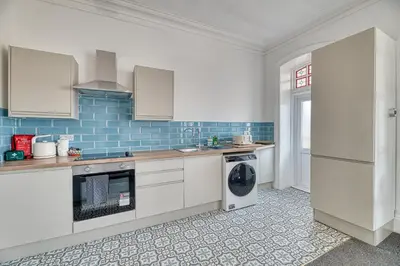 a kitchen with white cabinets and a dishwasher at Fairhaven View by Guestz in Lytham St Annes