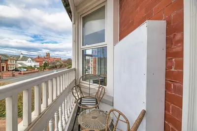 a balcony with two chairs and a window at Fairhaven View by Guestz in Lytham St Annes
