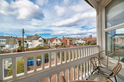 a balcony with a chair and a view of a city at Fairhaven View by Guestz in Lytham St Annes