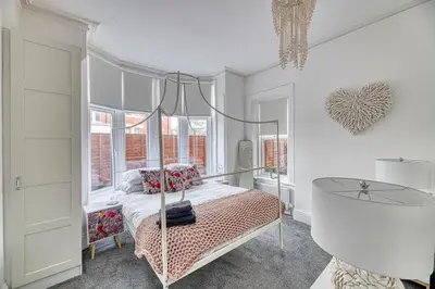 a bedroom with a canopy bed and a glass table at Fairhaven View by Guestz in Lytham St Annes