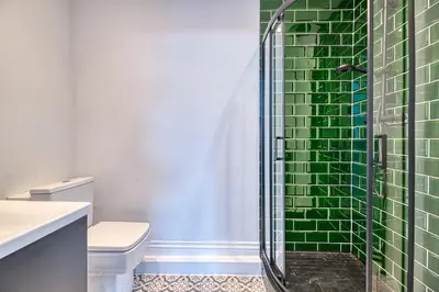 a bathroom with a shower with green tiles at Fairhaven View by Guestz in Lytham St Annes