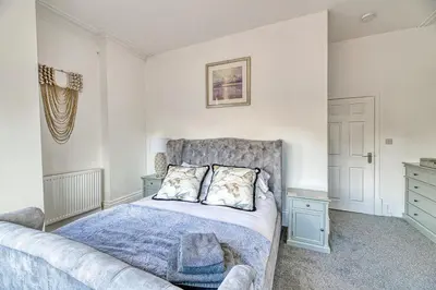 a bedroom with a bed and a couch at Fairhaven View by Guestz in Lytham St Annes