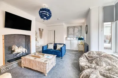 a living room with a blue couch and a fireplace at Fairhaven View by Guestz in Lytham St Annes