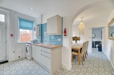 a kitchen with a table and a dining room at Fairhaven View by Guestz in Lytham St Annes