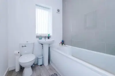 a white bathroom with a toilet and a sink at Blissful Luxury Home in Liverpool