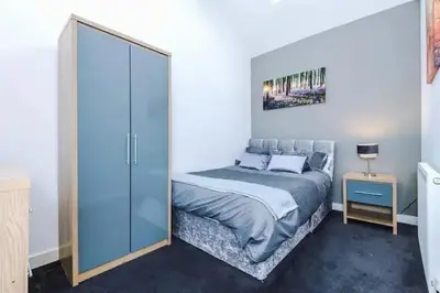 a bedroom with a bed and a glass door at Blissful Luxury Home in Liverpool
