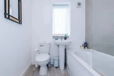 a white bathroom with a toilet and a sink at Blissful Luxury Home in Liverpool