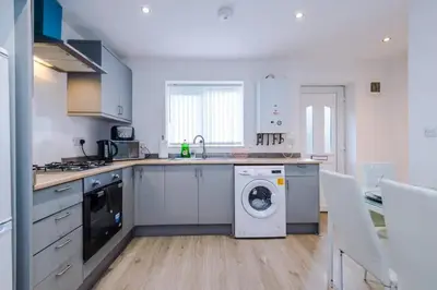 a kitchen with a washer and dryer in it at Blissful Luxury Home in Liverpool