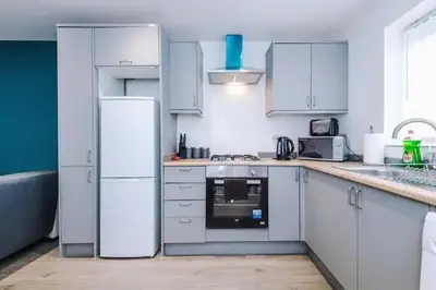 a kitchen with white appliances and white cabinets at Blissful Luxury Home in Liverpool