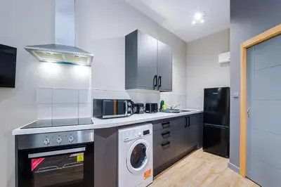 a kitchen with a washing machine and a washer at Stylish 2 Bedroom Apartment in Central Wigan by MDGC Developments Ideal For Weekends Away and Business Guests in Wigan