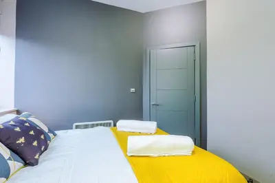 a bedroom with a bed with two towels on it at Stylish 2 Bedroom Apartment in Central Wigan by MDGC Developments Ideal For Weekends Away and Business Guests in Wigan