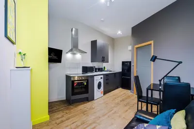a room with a kitchen and a living room at Stylish 2 Bedroom Apartment in Central Wigan by MDGC Developments Ideal For Weekends Away and Business Guests in Wigan