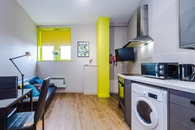 a kitchen with a washing machine and a dining room at Stylish 2 Bedroom Apartment in Central Wigan by MDGC Developments Ideal For Weekends Away and Business Guests in Wigan