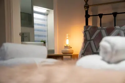 a bedroom with a bed and a lamp on a table at Birkdale Retreat in Southport