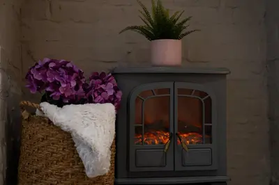 a stove with a fire in a room with flowers at Birkdale Retreat in Southport