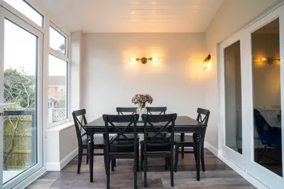 a dining room with a black table and chairs at Birkdale Retreat in Southport