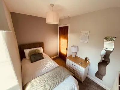 a small bedroom with a bed and a night stand at Delightful 3 bedroom Cottage in Haverigg in Haverigg