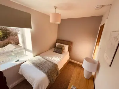 a small bedroom with a bed and a window at Delightful 3 bedroom Cottage in Haverigg in Haverigg