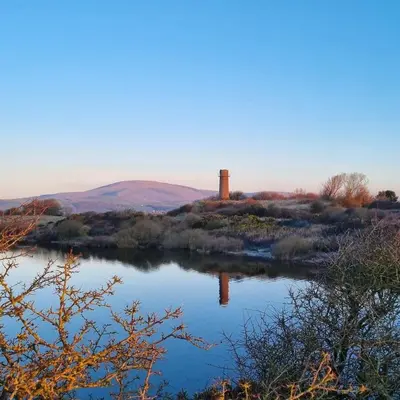 a view of a river with a tower in the distance at Delightful 3 bedroom Cottage in Haverigg in Haverigg