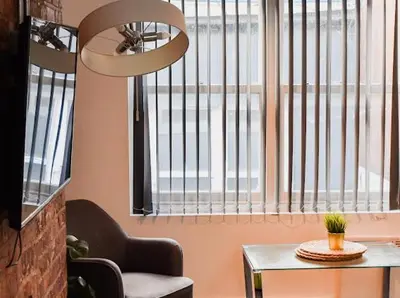 a room with a chair and a table and a window at CASTLE STREET - City Centre 2 bedroomed Apt sleeps 8 in Liverpool