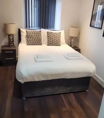 a bedroom with a large bed with two lamps at CASTLE STREET - City Centre 2 bedroomed Apt sleeps 8 in Liverpool