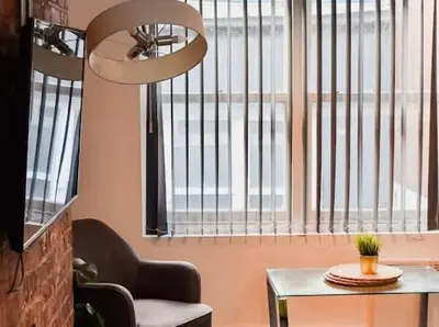 a room with a chair and a table and a window at CASTLE STREET - City Centre 2 bedroomed Apt sleeps 8 in Liverpool