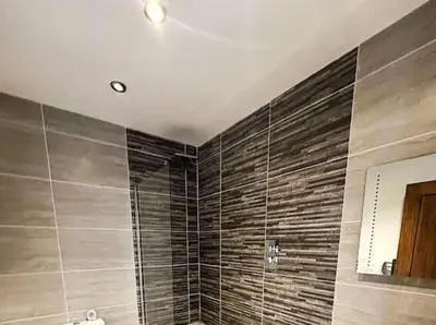 a bathroom with a large shower with brown tiles at CASTLE STREET - City Centre 2 bedroomed Apt sleeps 8 in Liverpool