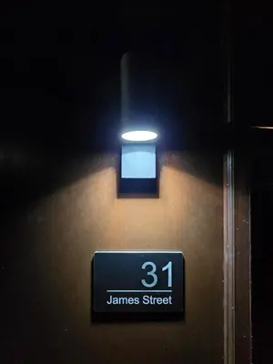 a sign on a wall with a light on it at Modern Studio Apartment in Blackburn Town Centre in Blackburn