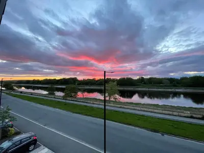 a road with a view of a river and a sunset at Small Double Room in Lancaster Riverside - 15 Minutes Walk to City Centre in Torrisholme