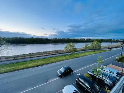 a car driving down a road next to a river at Small Double Room in Lancaster Riverside - 15 Minutes Walk to City Centre in Torrisholme