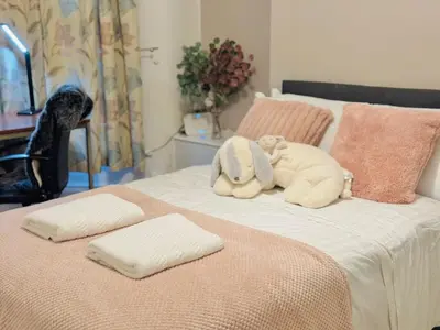 two stuffed animals sitting on top of a bed at Room 1 Shared House in Bootle in Litherland