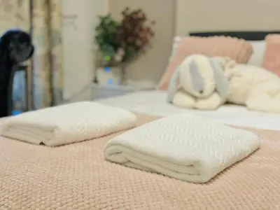 two white towels on top of two beds at Room 1 Shared House in Bootle in Litherland