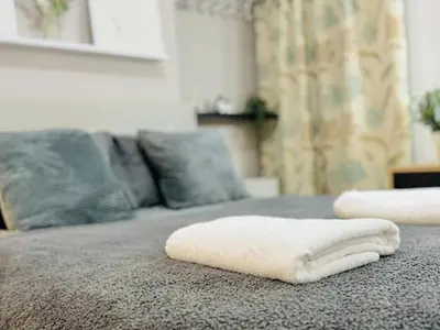 two white towels sitting on top of a bed at Room 3 Shared House in Bootle in Litherland