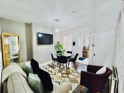 a living room with a couch and a table and chairs at Room 3 Shared House in Bootle in Litherland