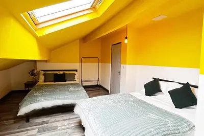 two beds in a room with yellow walls and a skylight at Willow Suite - 3br - Sleeps 8 - Central Blackpool in Blackpool