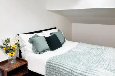 a bedroom with a bed with green and white pillows at Willow Suite - 3br - Sleeps 8 - Central Blackpool in Blackpool