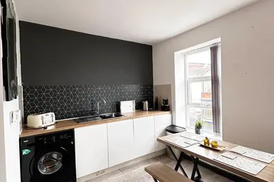 a kitchen with a washer and dryer and a table at Willow Suite - 3br - Sleeps 8 - Central Blackpool in Blackpool