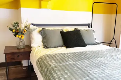a bedroom with a bed and a vase of flowers on a table at Willow Suite - 3br - Sleeps 8 - Central Blackpool in Blackpool