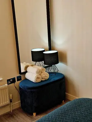 a stack of towels on a blue ottoman in a bedroom at Falkner Square in Liverpool